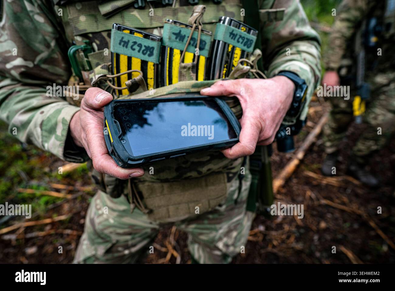 A British Army soldier holds a phone-sized electronic screen display ...