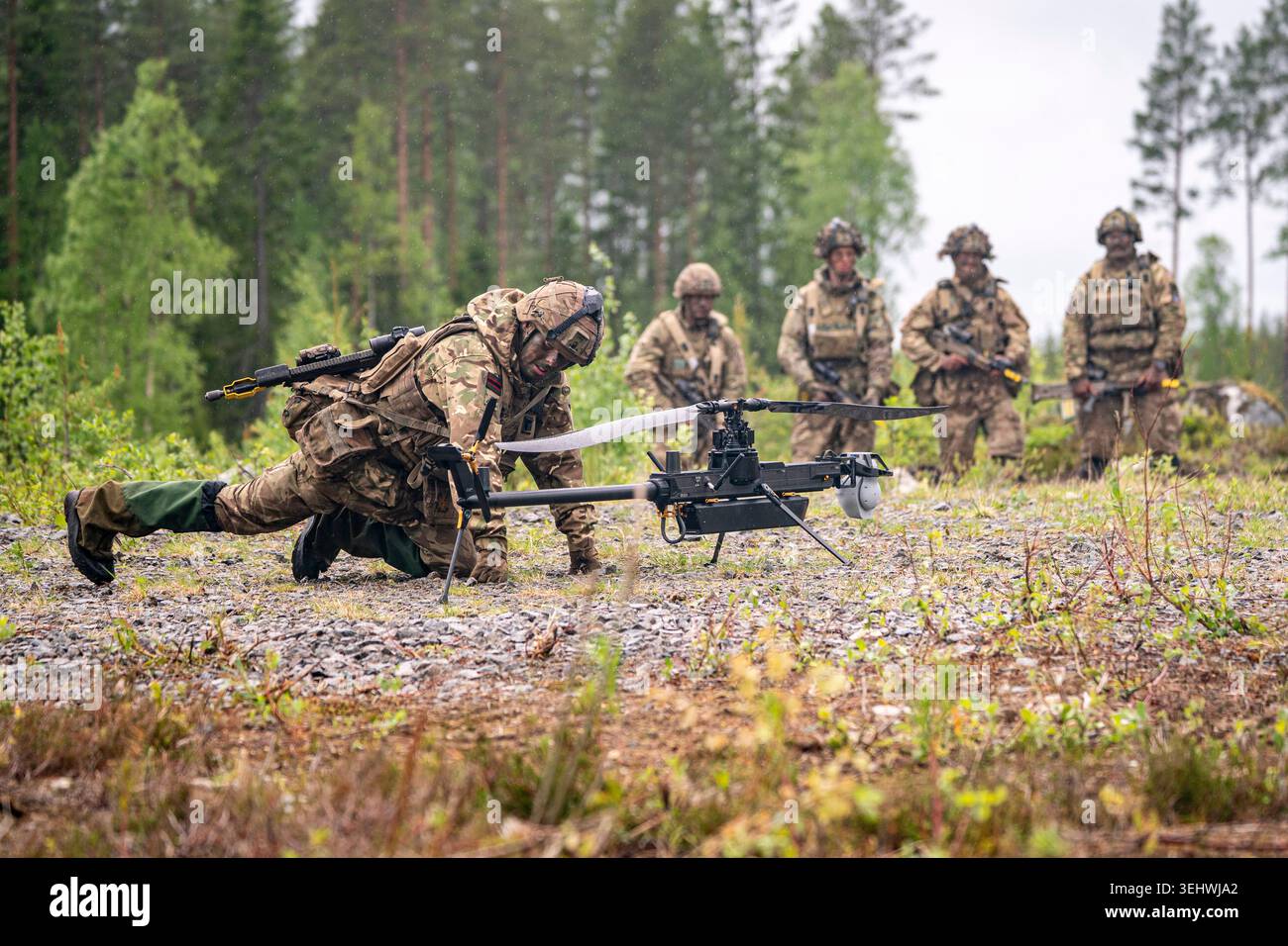 British Army soldiers from 3 Rifles check a single-rotor helicopter ...