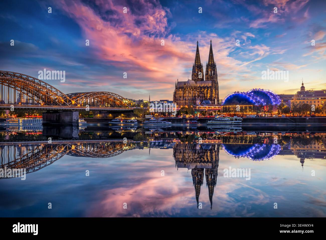 Beautiful view of the illuminated Cathedral in Cologne, Germany, just after sunset with reflections in the river Rhine Stock Photo