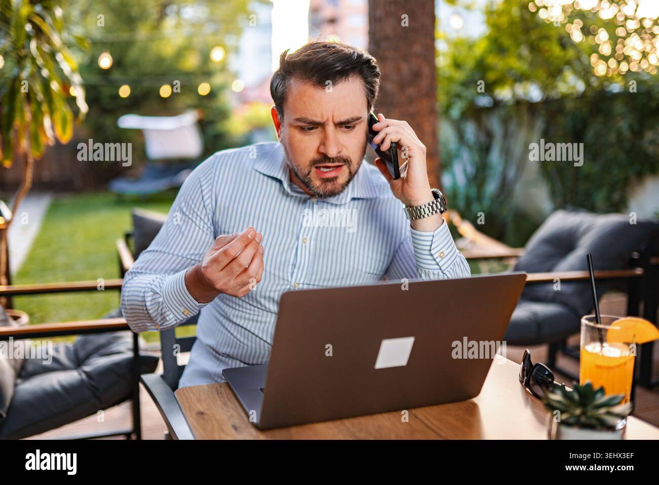 Stressed businessman having difficult phone call working outdoors Stock Photo
