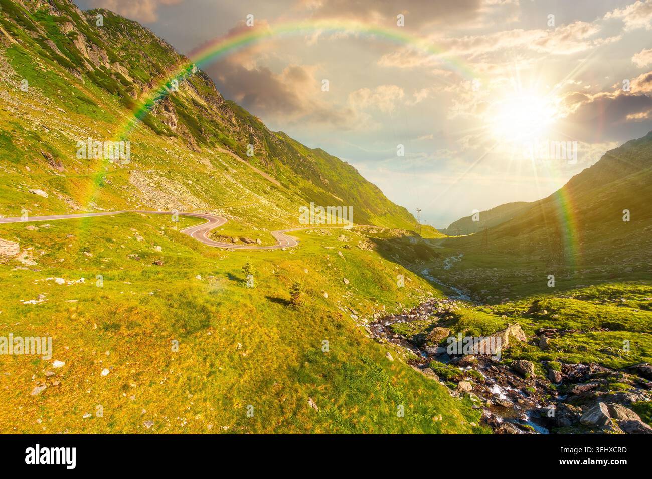 sunset over road through mountains winding uphill. popular highway travel destination of Romania. nice view of mountain on summertime weather. road jo Stock Photo