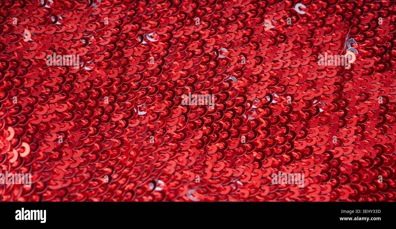 Sequin fabric macro texture, color shiny carnival background. Red glitter dress pattern, decorative metallic material design close up Stock Photo