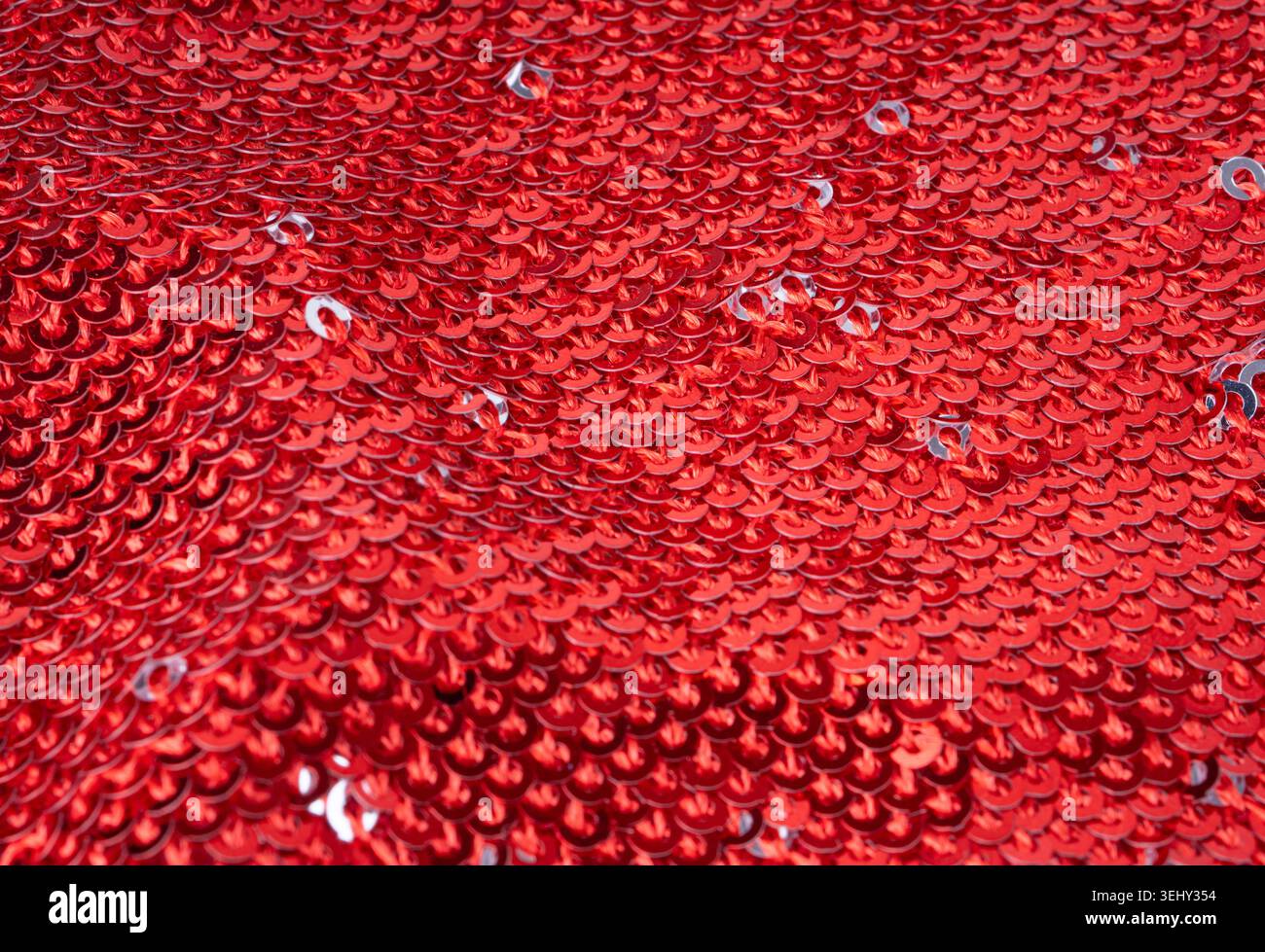 Sequin fabric macro texture, color shiny carnival background. Red glitter dress pattern, decorative metallic material design close up Stock Photo