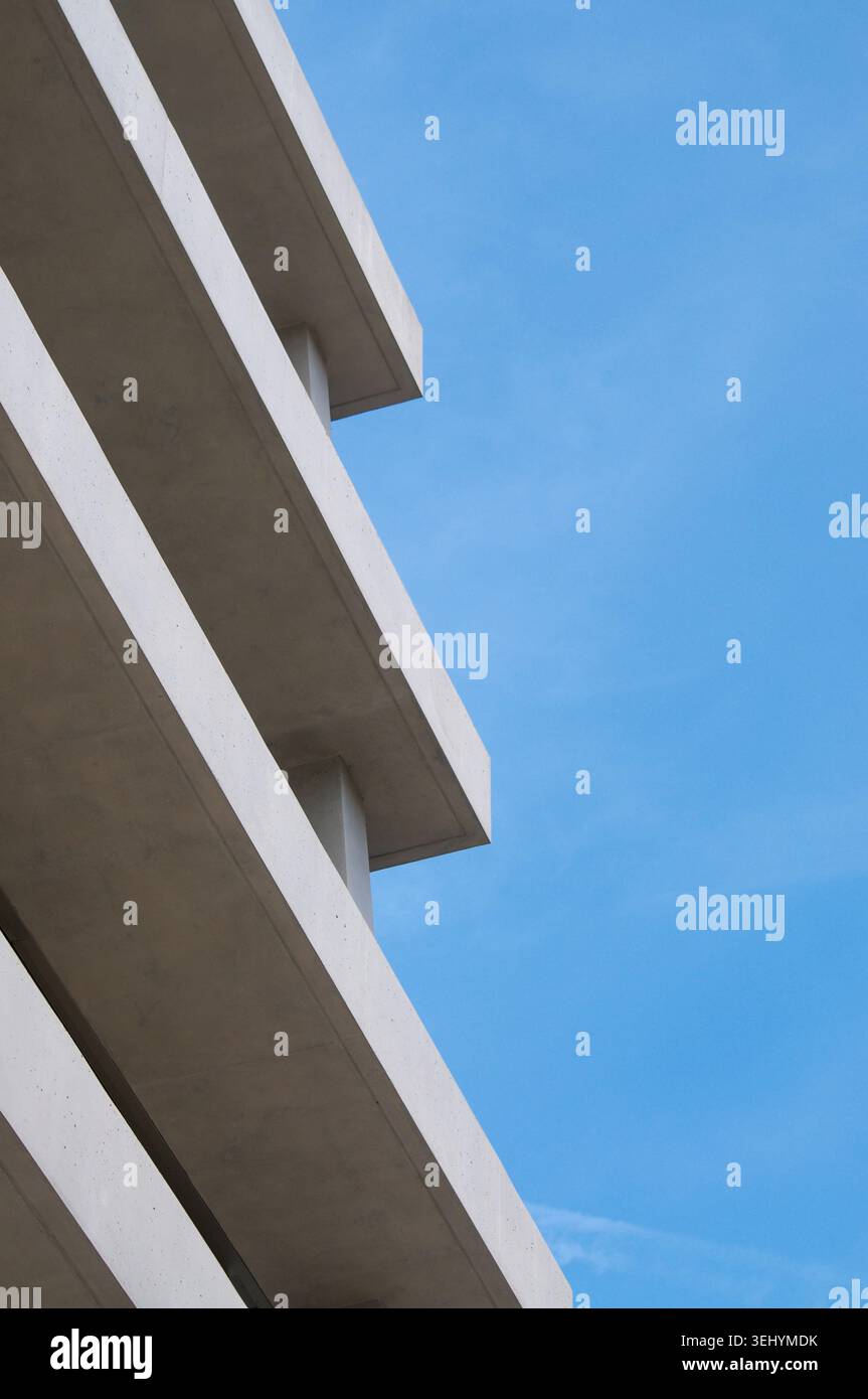 Close up architectural detail of a modern brutalist concrete building exterior. Minimalist abstract pattern of raw cement walls, sharp lines, and shad Stock Photo