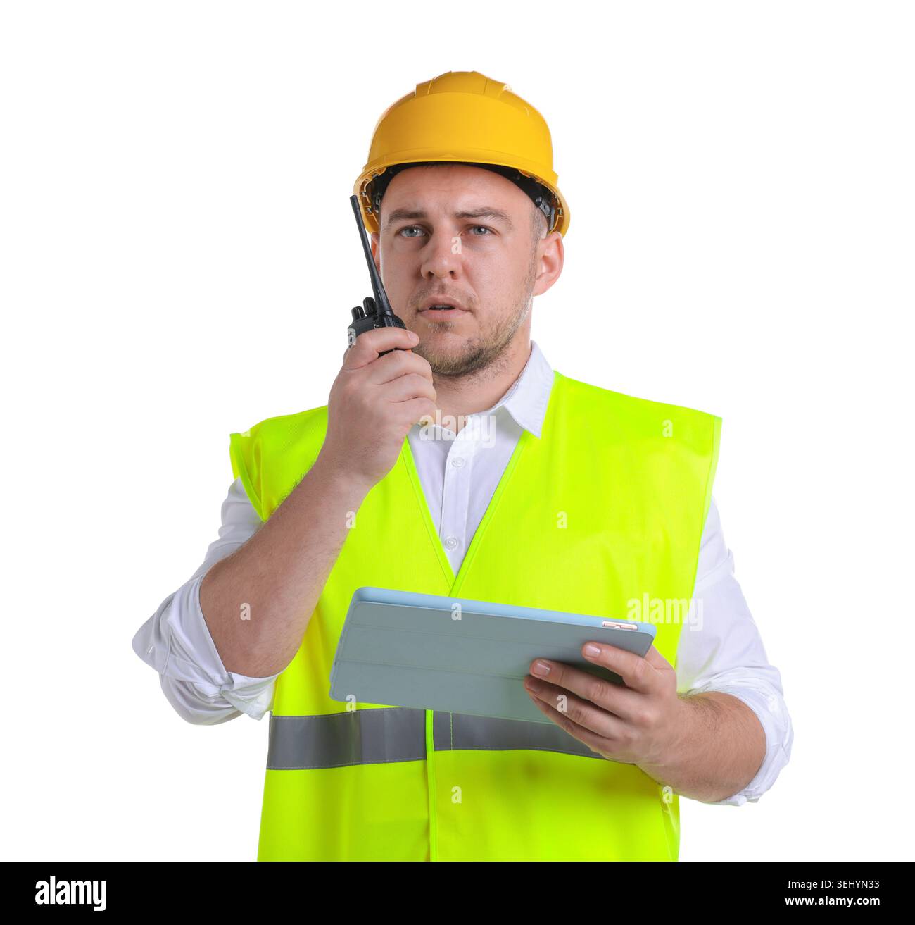 Man in helmet with tablet using walkie talkie on white background Stock Photo