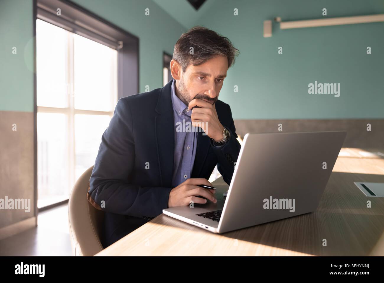 Businessman using laptop, focused on data analysis, searching problem solution Stock Photo