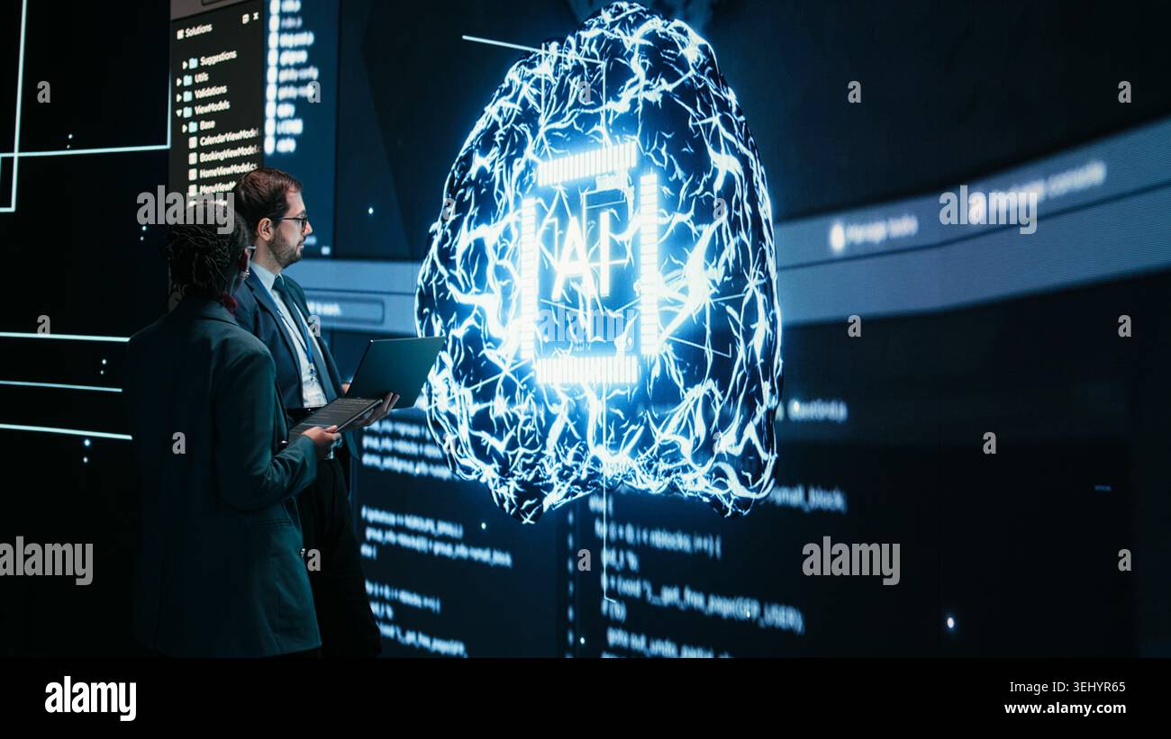Engineering team looks at AI machine learning self writing code on screen, autonomy concept. Teamworking colleagues reviewing self sustaining artificial intelligence model, doing brainstorming Stock Photo