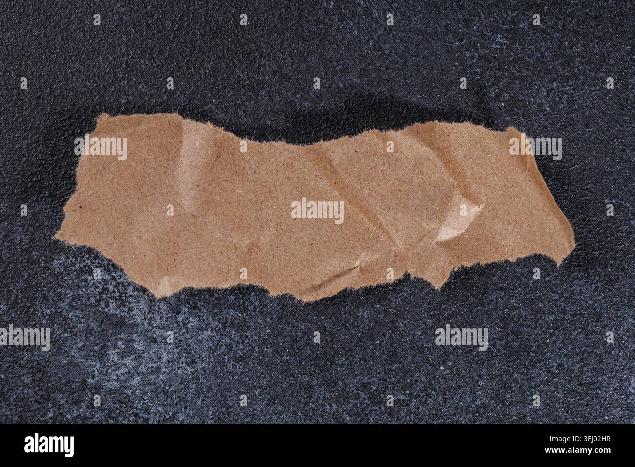 Horizontal Torn Kraft Paper Strip on Dark Background Stock Photo