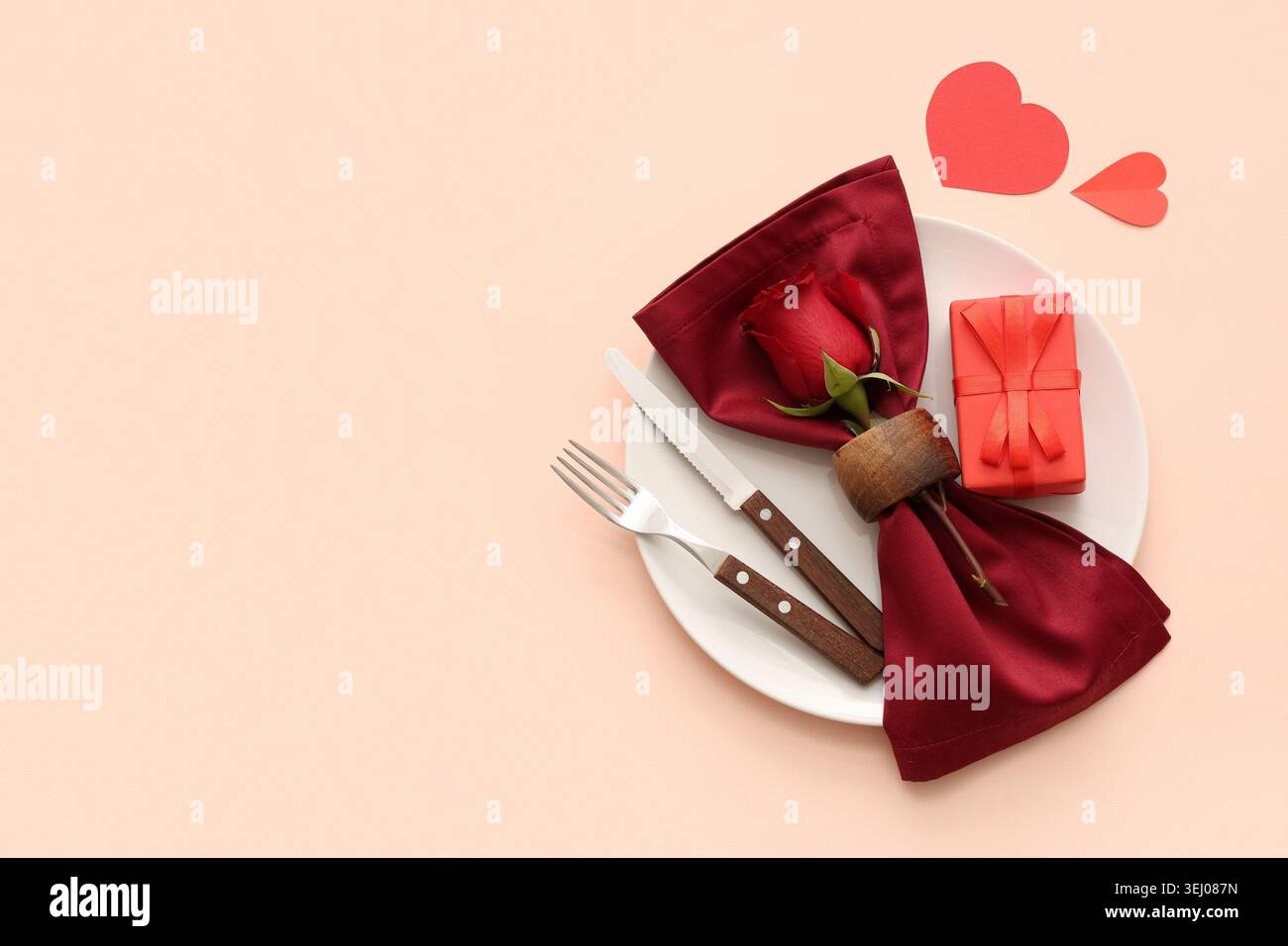 Beautiful table setting with red rose, paper heart and gift box on ...