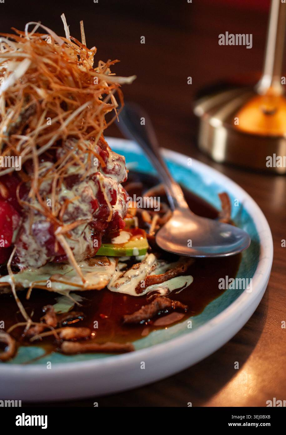 wonton cracker with fresh tuna cubes and fried onions with celery and garlic cream. Stock Photo