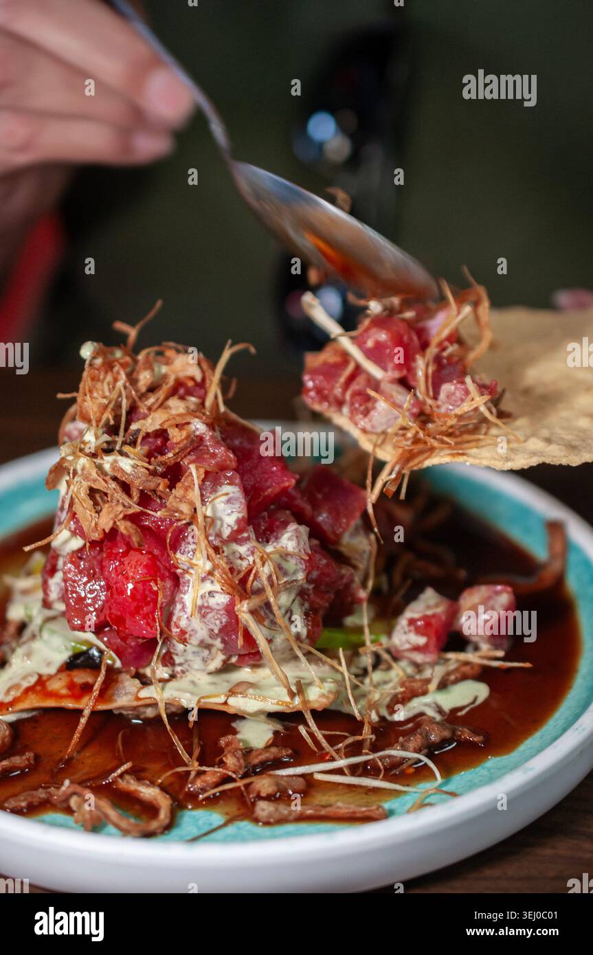 wonton cracker with fresh tuna cubes and fried onions with celery and garlic cream. Stock Photo