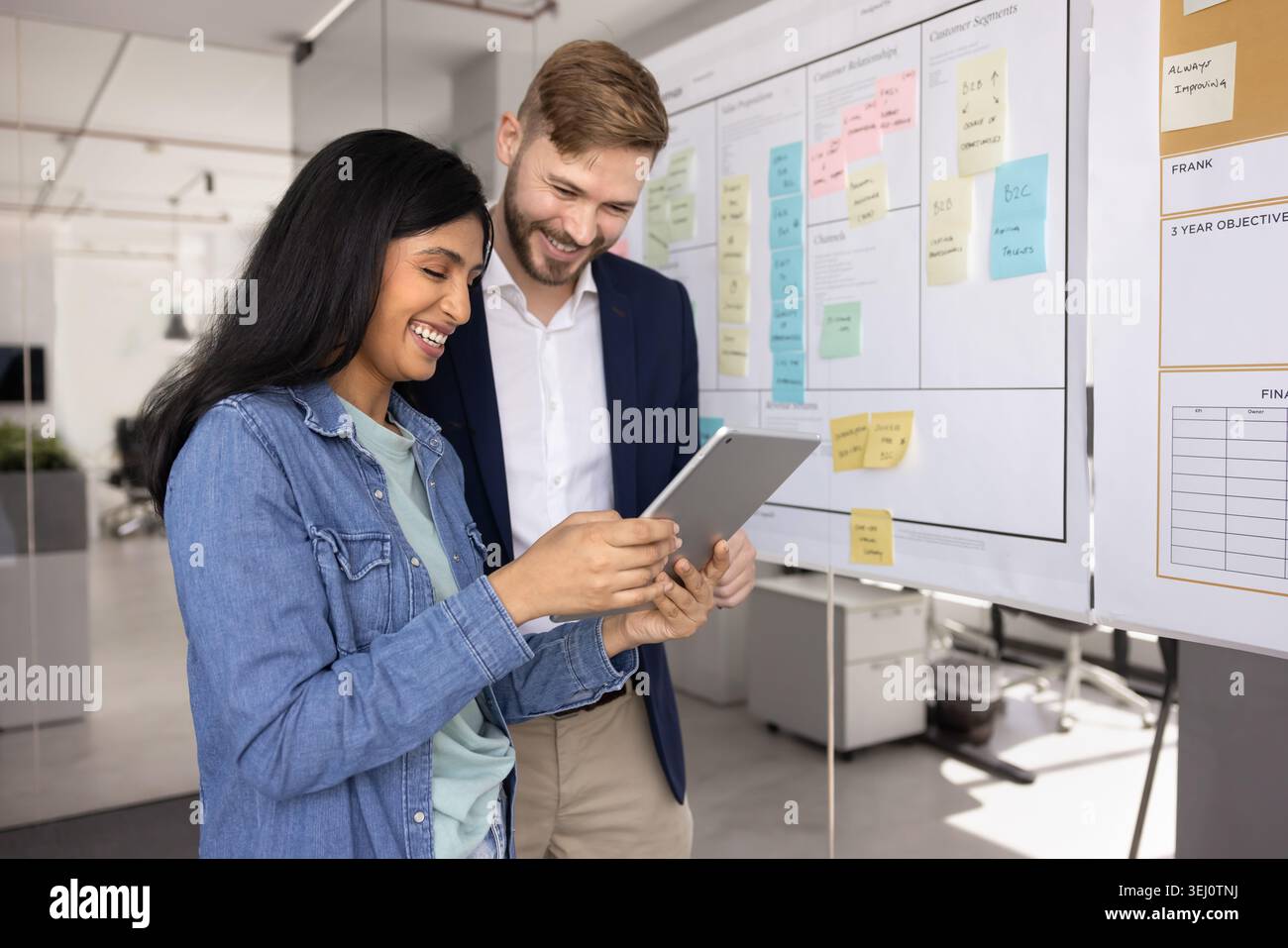 Teammates using tablet working together in office Stock Photo