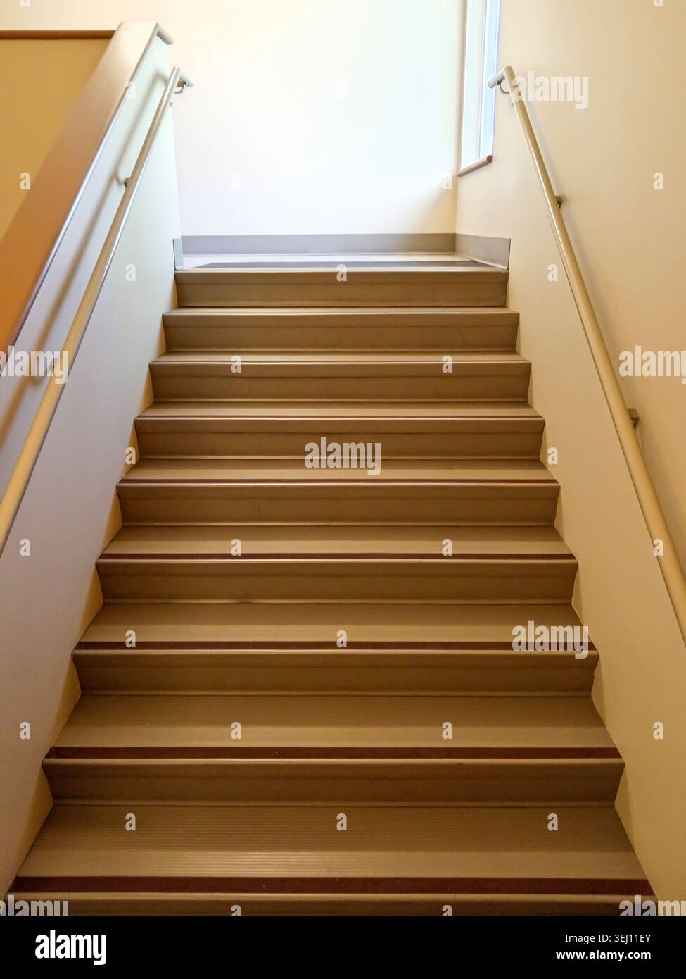 The stairwell shows safety handrails for an emergency exit in a nursing home building in Canada. The stairs lead to an exit door. Stock Photo