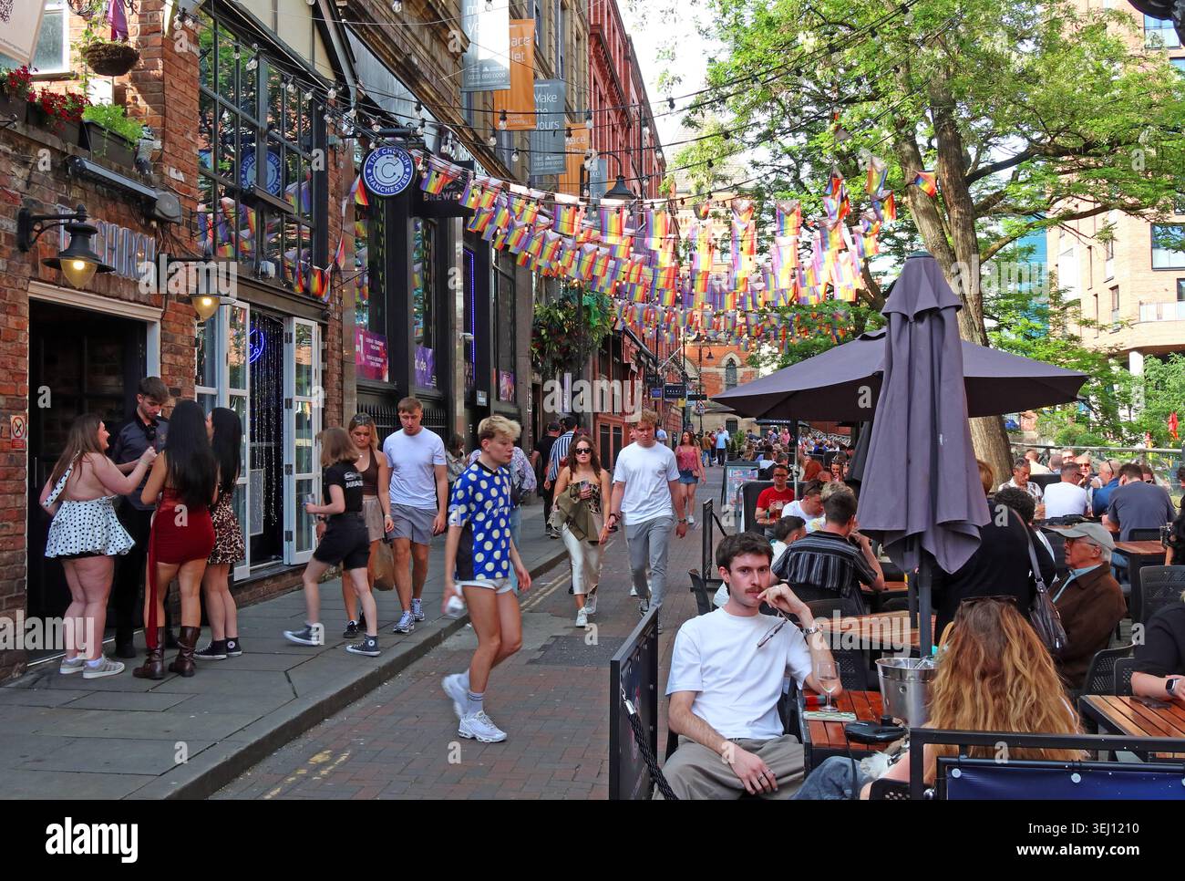 Busy summer hospitality outside The Church on Canal Street in Manchester Gay Village, with Pride bunting and outdoor seating. Stock Photo