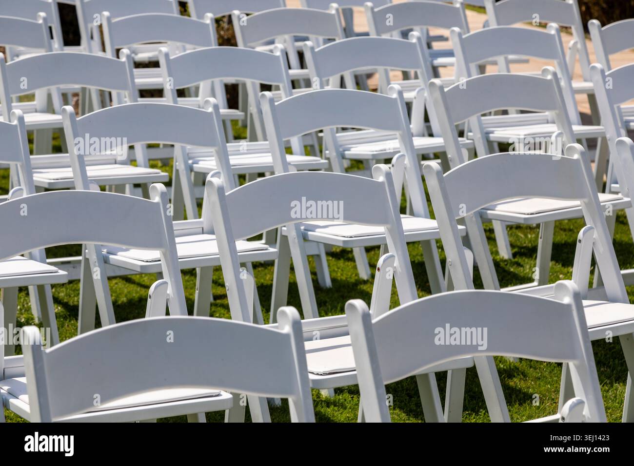 White chairs arranged for wedding guests Stock Photo