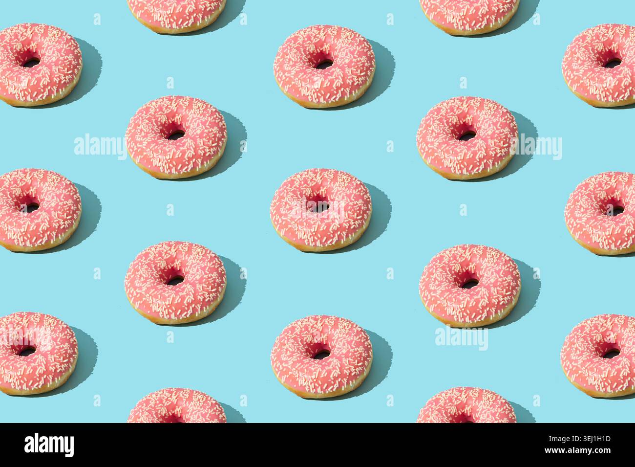 Pink donut pattern on light blue background. Creative food concept. Delicious dessert design idea. Stock Photo
