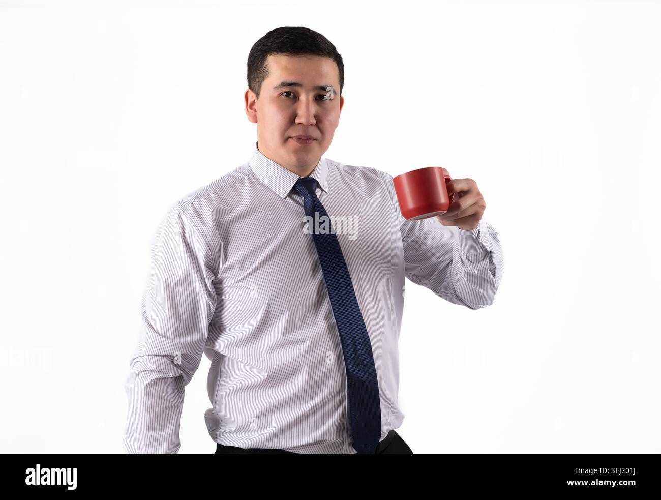 Young man drinking hot beverage from a red mug Stock Photo