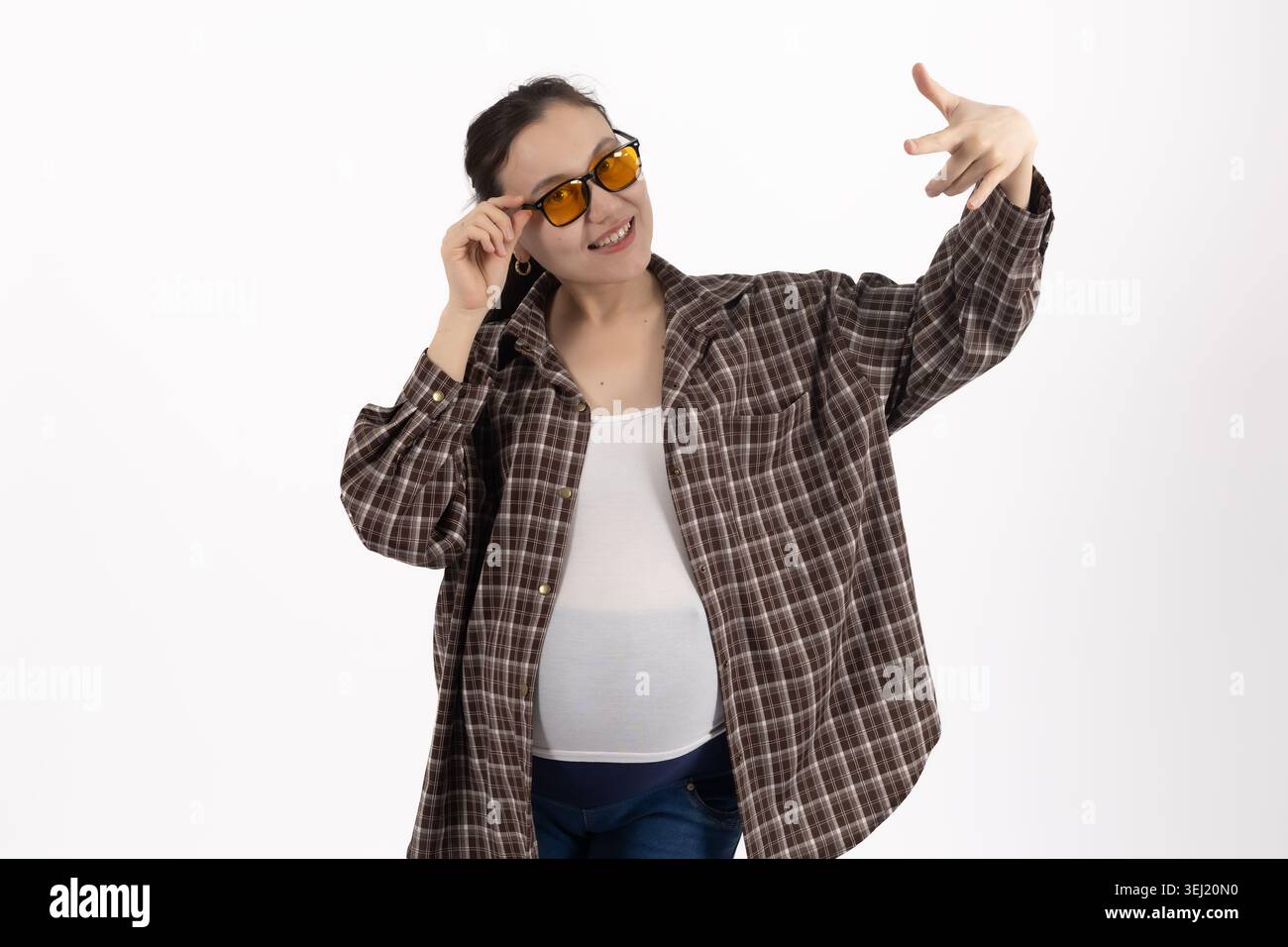 Young pregnant woman posing with sunglasses in studio Stock Photo
