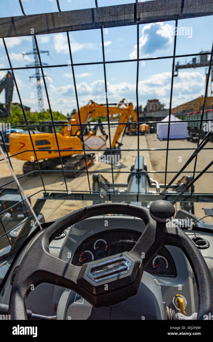 POV from heavy machinery cabin overlooking excavator equipment yard Stock Photo