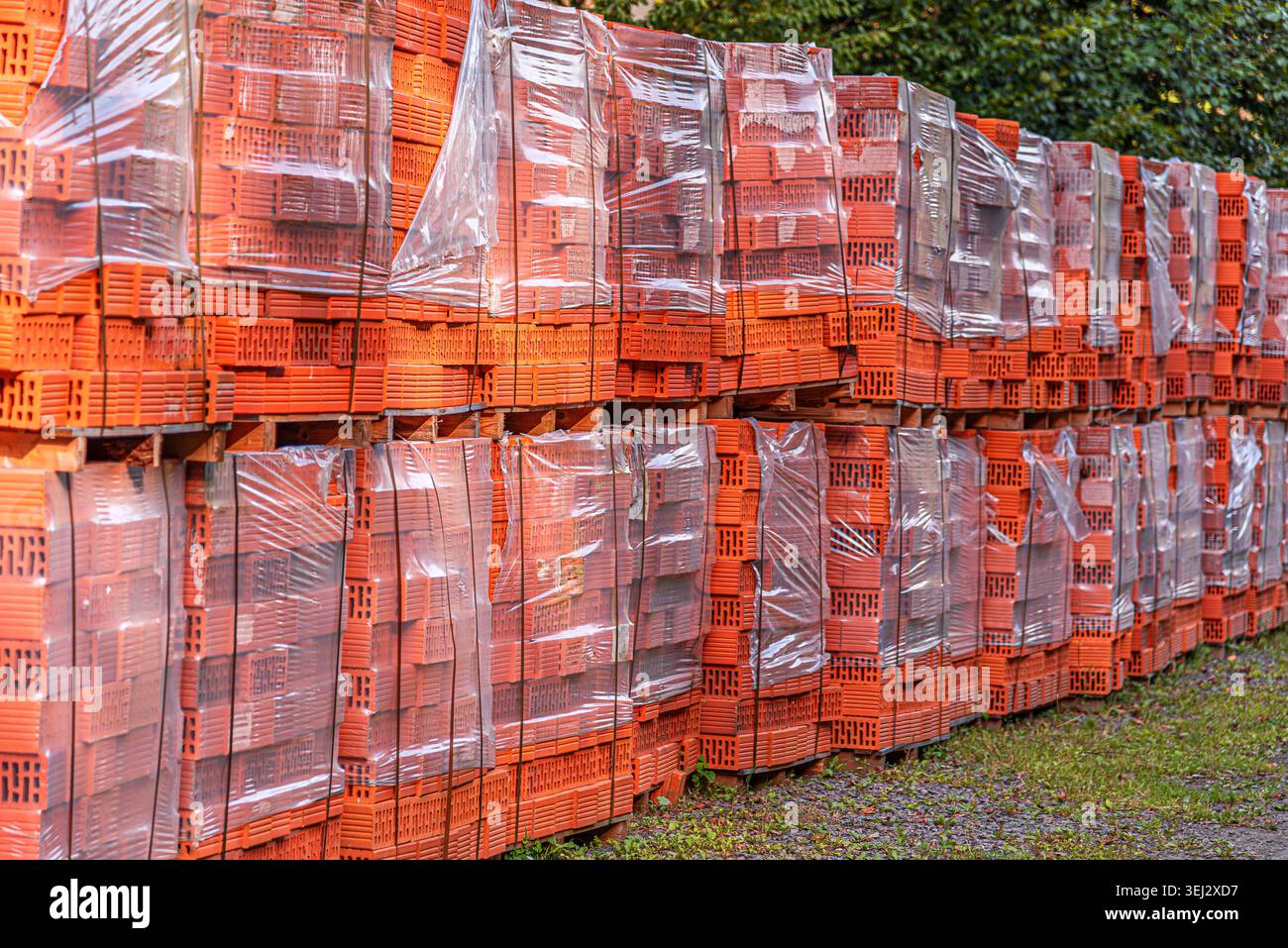 A large stack of orange perforated clay bricks. Stock Photo