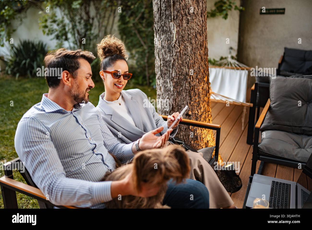 Couple relaxing outdoors with dog using digital tablet Stock Photo