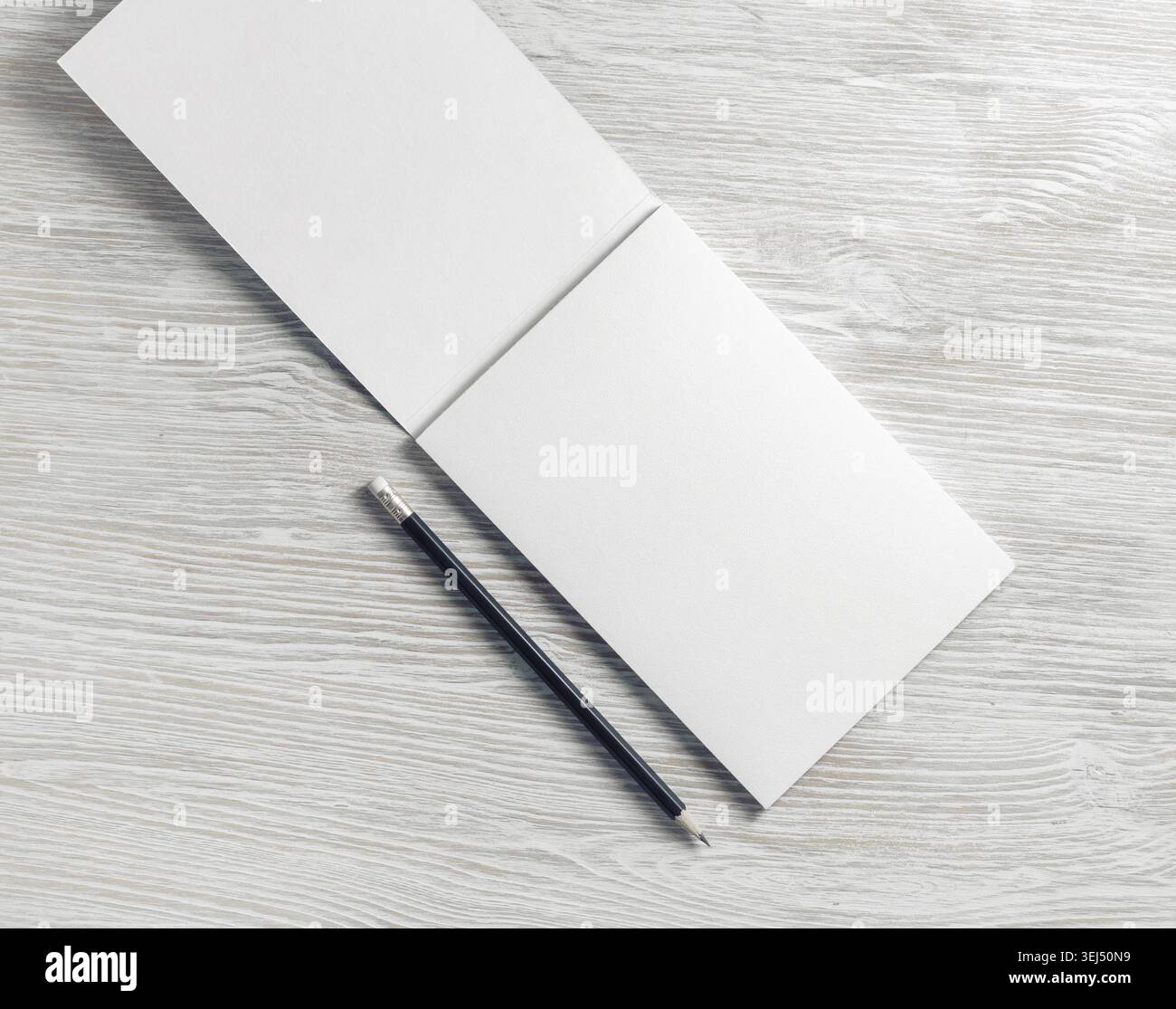 Opened blank notepad and pencil on light wooden background. Flat lay Stock Photo