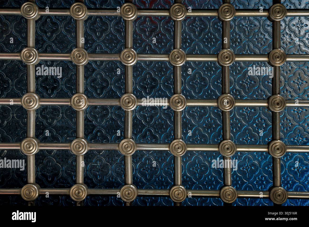 Decorative Metal Grille Over Blue Patterned Surface Stock Photo