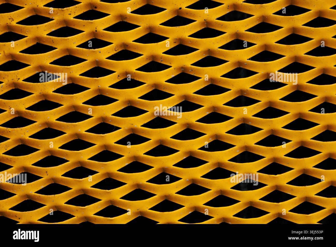 Yellow Expanded Metal Mesh Texture on Black Background Stock Photo