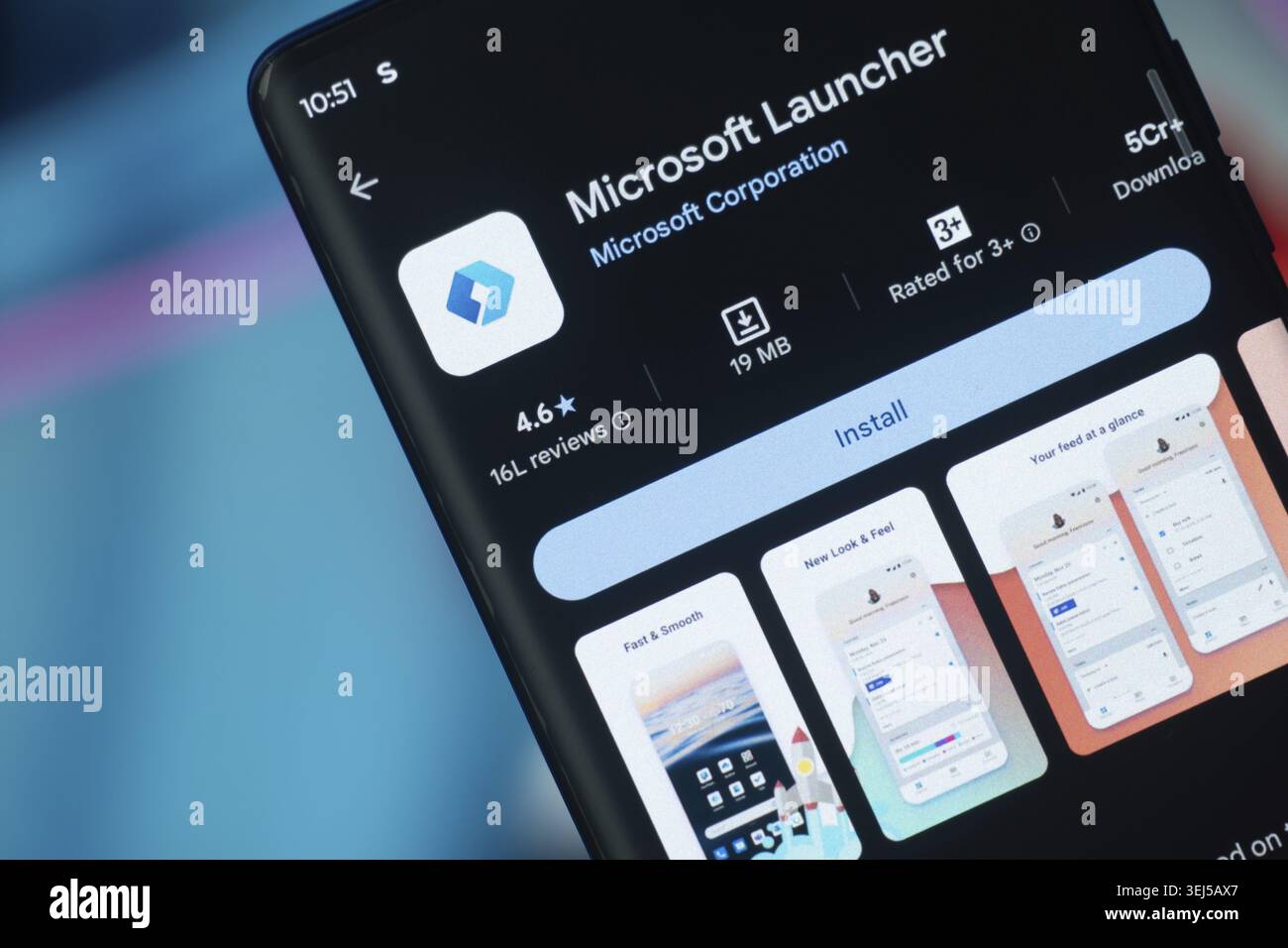 Dhaka, Bangladesh 26 Dec 2025:Smartphone featuring Microsoft Launcher app and earphones against a blue background Stock Photo