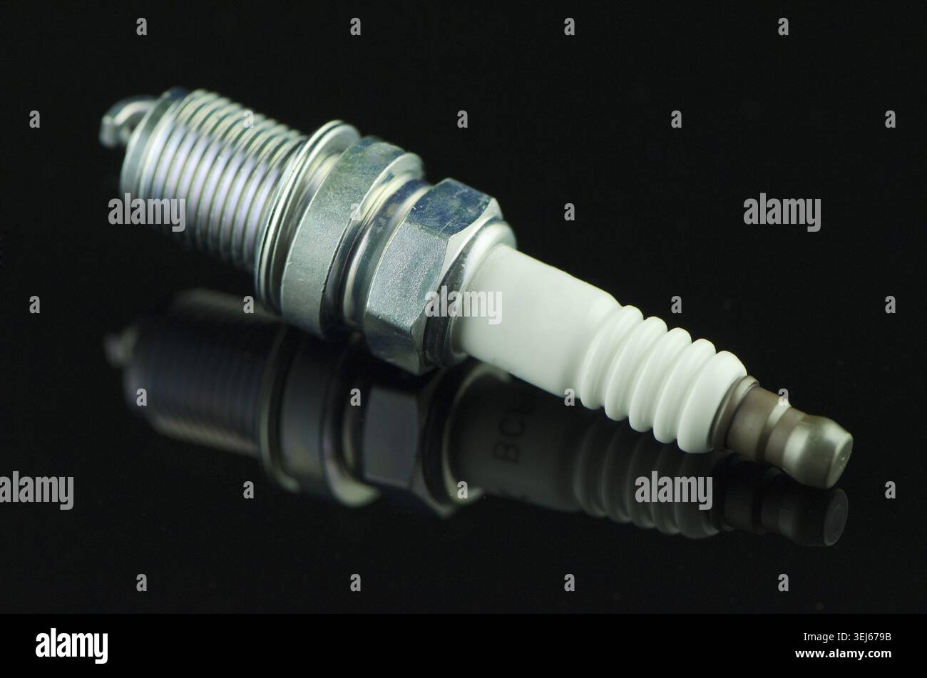 Spark-plug on black reflective background Stock Photo