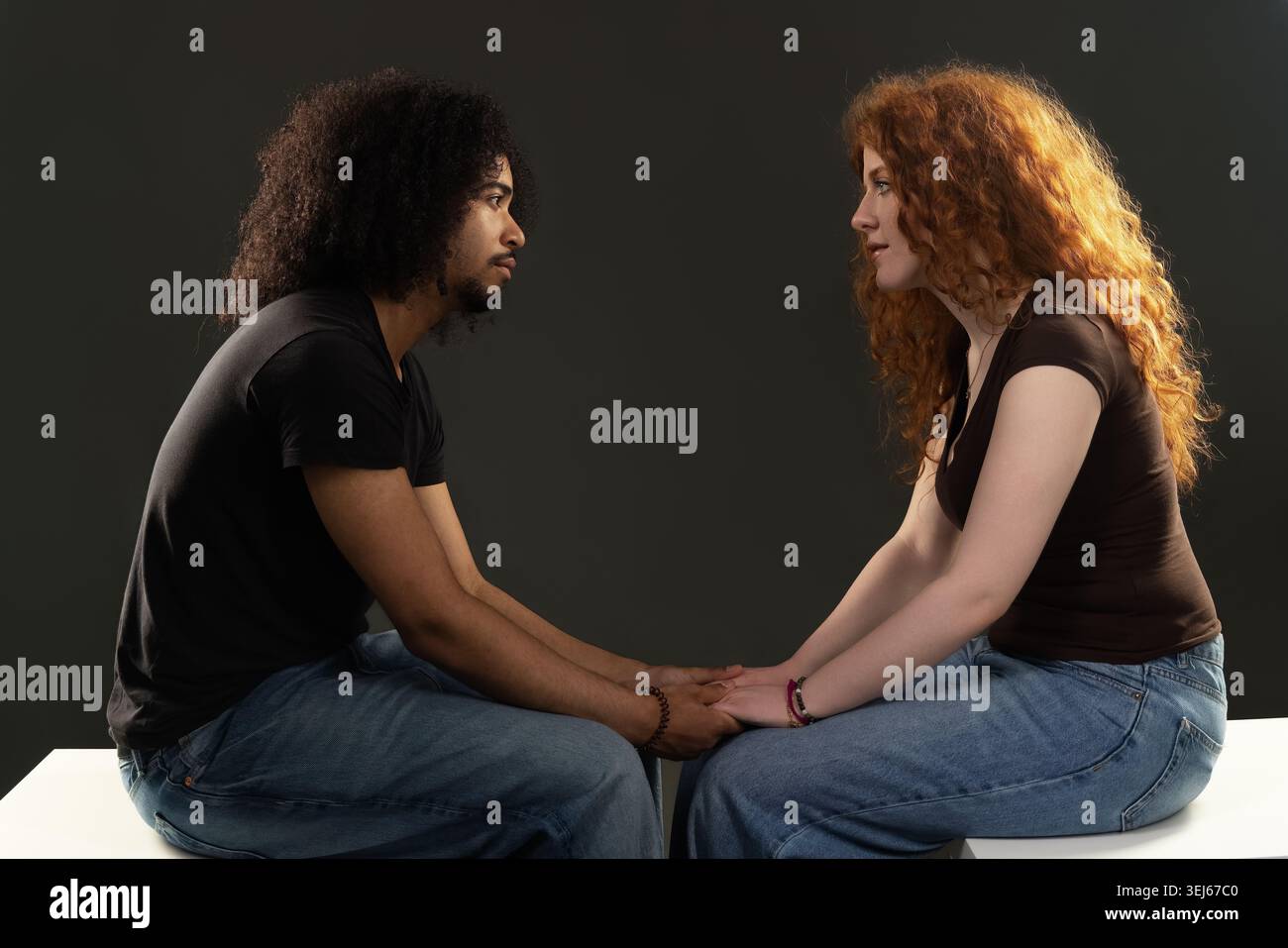 Young diverse couple communicating while holding hands, symbolizing connection and trust Stock Photo
