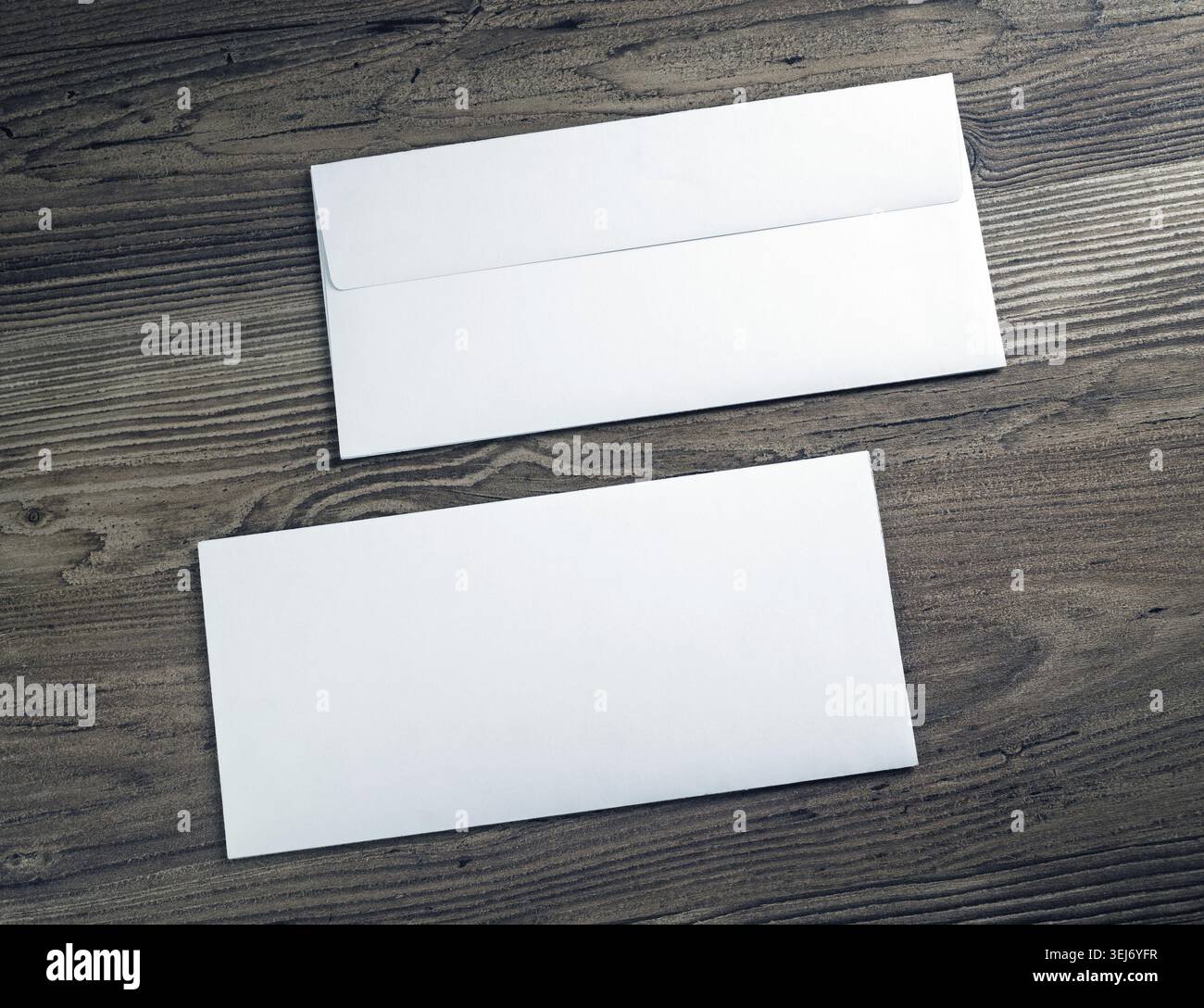 Two white blank envelopes on wooden background. Front and back side Stock Photo