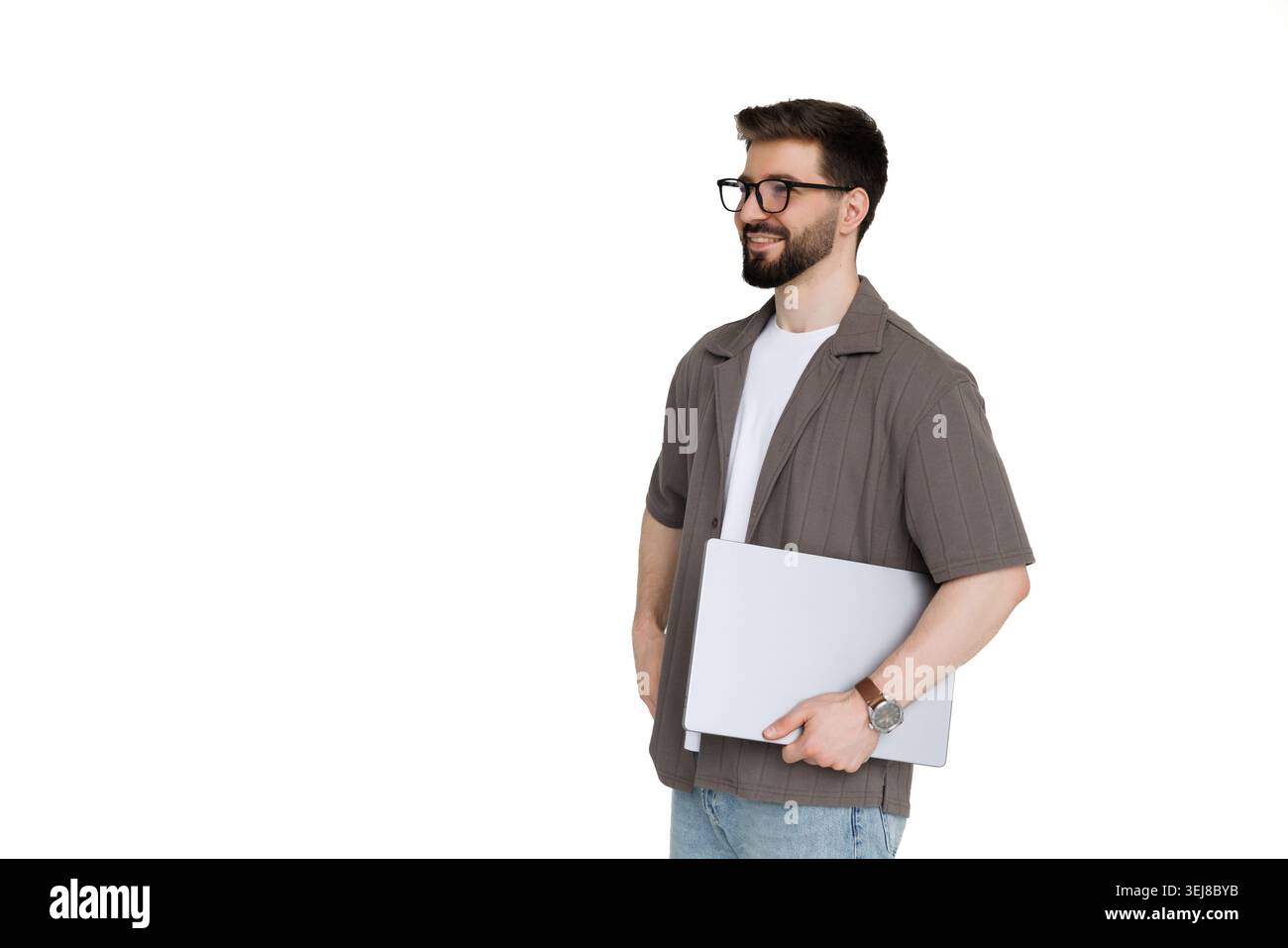 Young man holding laptop while walk on white background Stock Photo