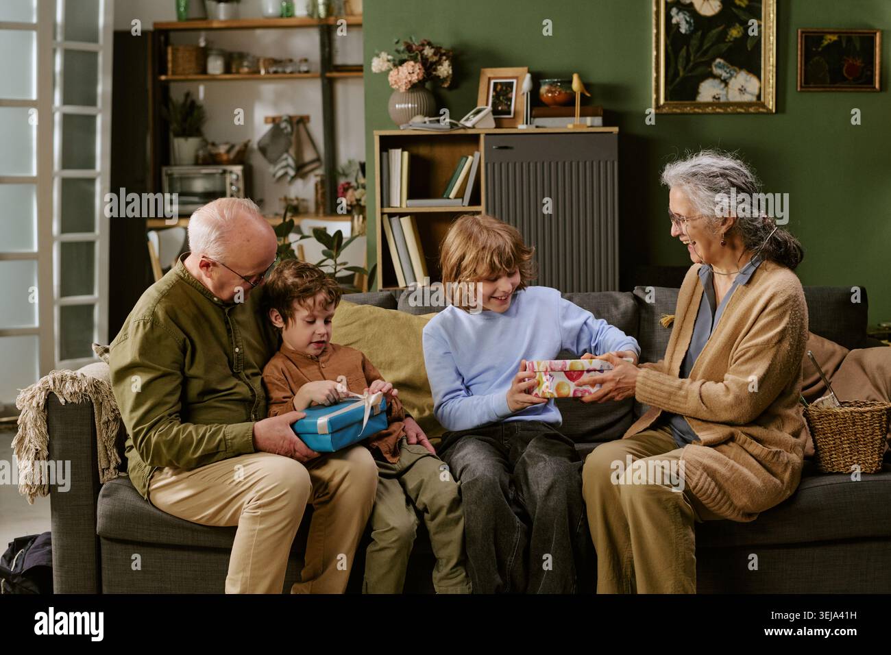 Senior Couple with Children Exchanging Gifts at Family Gathering Stock Photo