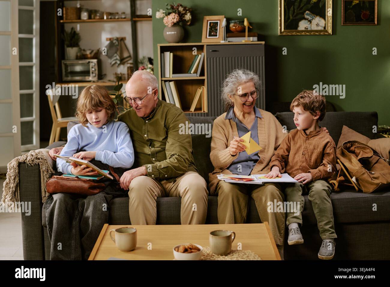 Senior Couple Helping Grandchildren Learning at Home Together Stock Photo