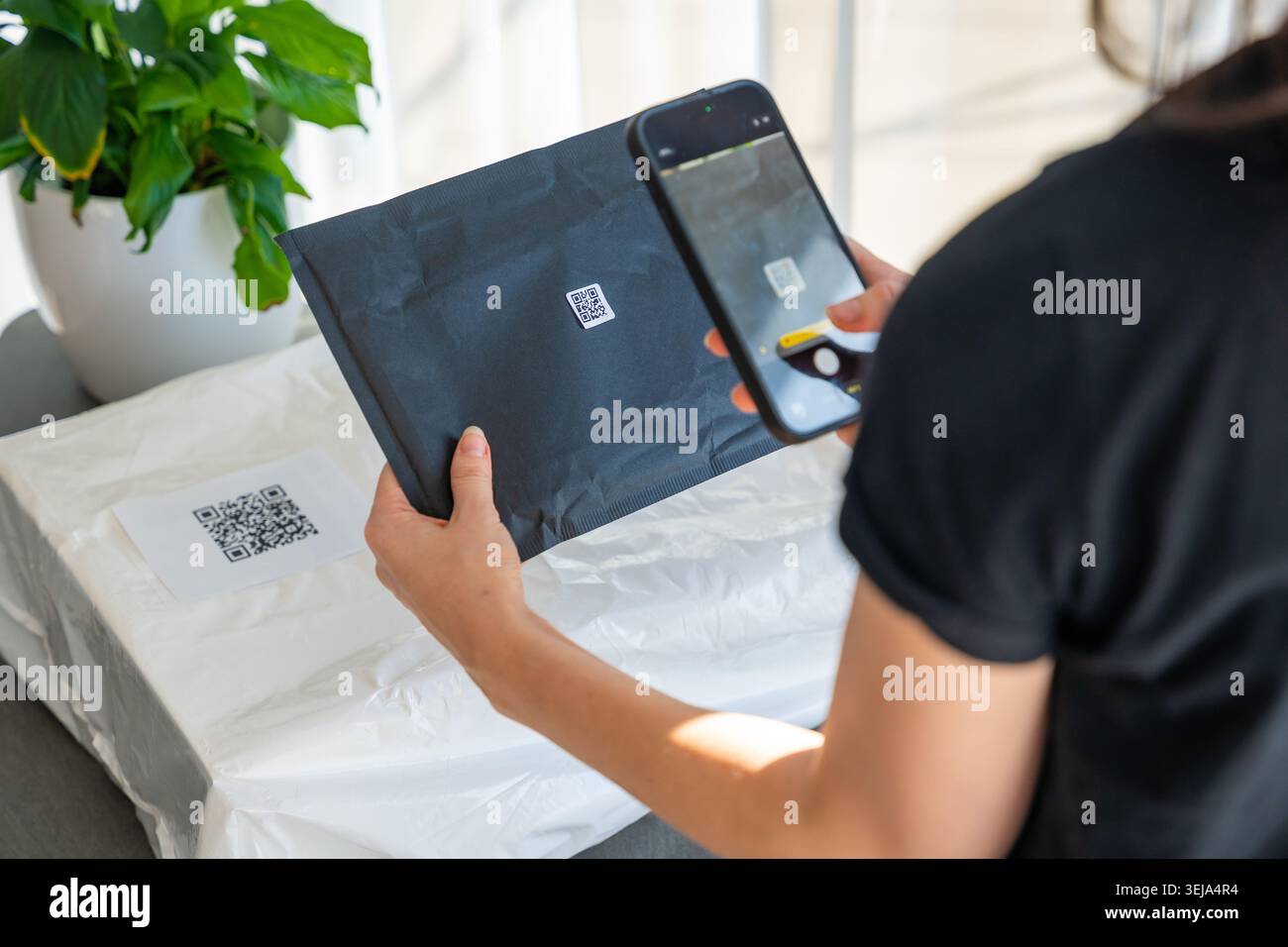 Smartphone scanning small QR code on parcel with focus on label for ...