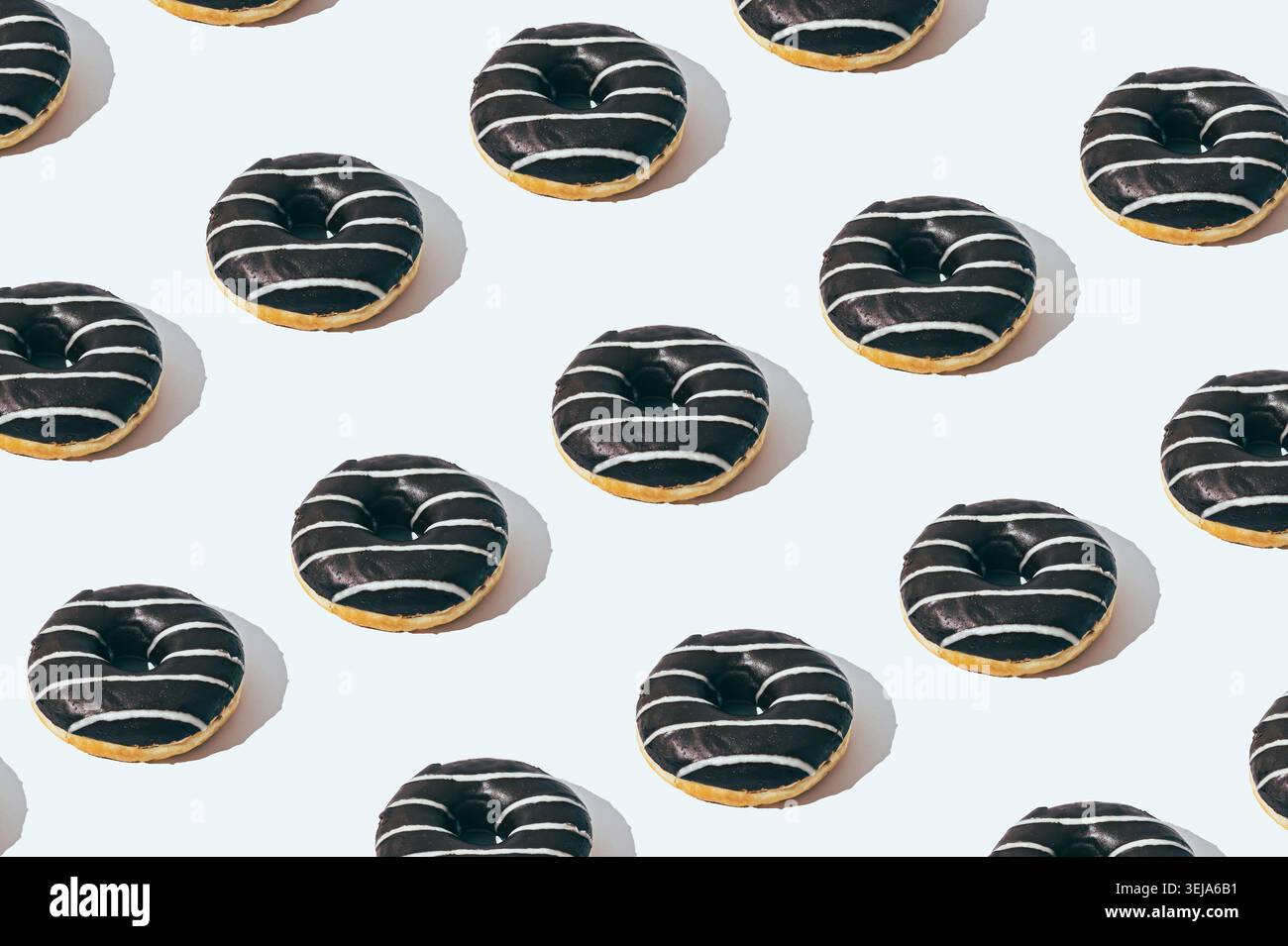 Chocolate donut pattern on white background. Creative food concept. Delicious dessert design idea. Stock Photo