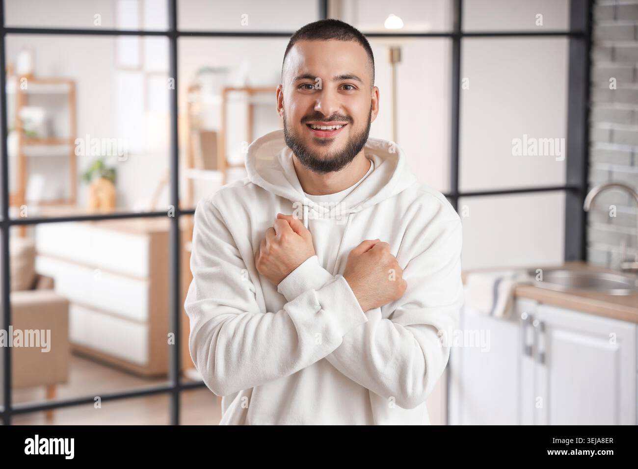 Young man using sign language in kitchen Stock Photo