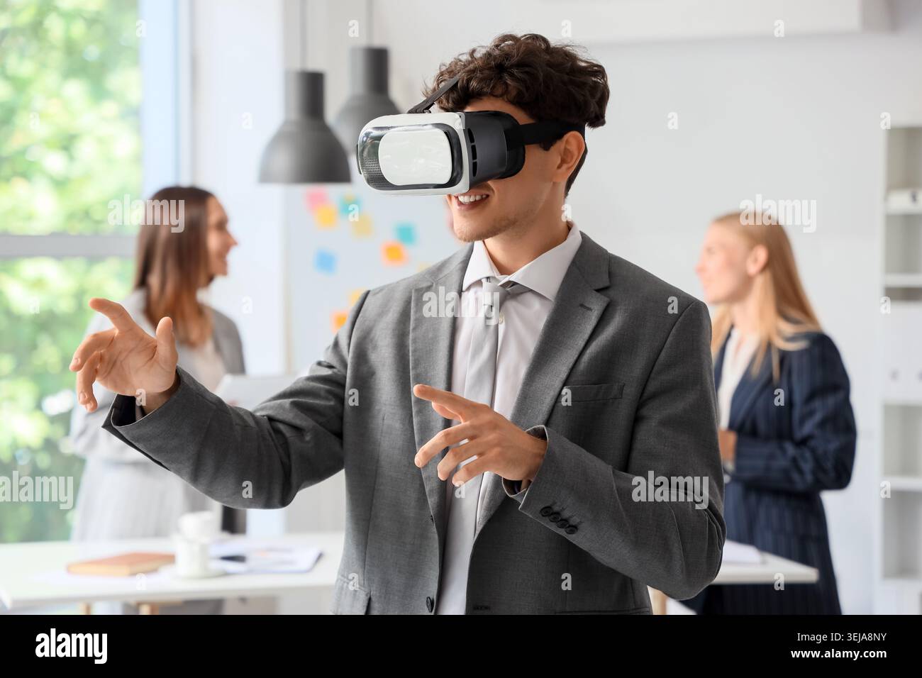 Young businessman using VR glasses in office Stock Photo