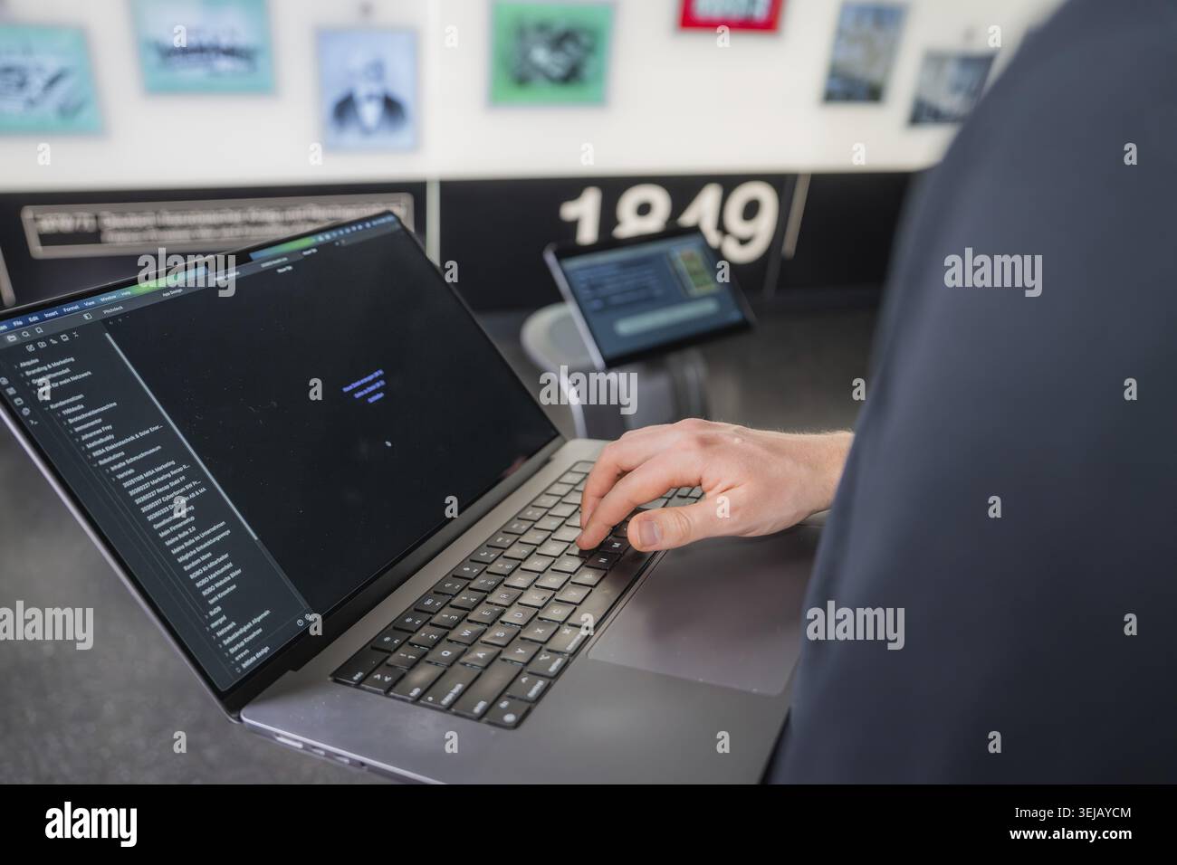 Person working on a laptop in a room with modern technologies and murals in the background, museum robot Robolutions, Marchivum, Mannheim, Germany Stock Photo
