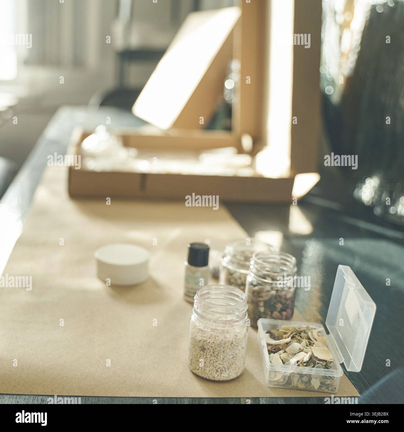 Eco-friendly packaging setup with natural materials and jars on table in sunlight Stock Photo