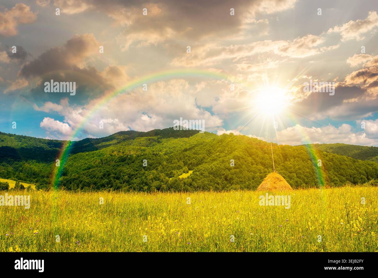 sunset over rural fields near pikui mountain in summertime. beautiful view of agricultural area. gorgeous mountain ridge with haystack on a grassy pas Stock Photo