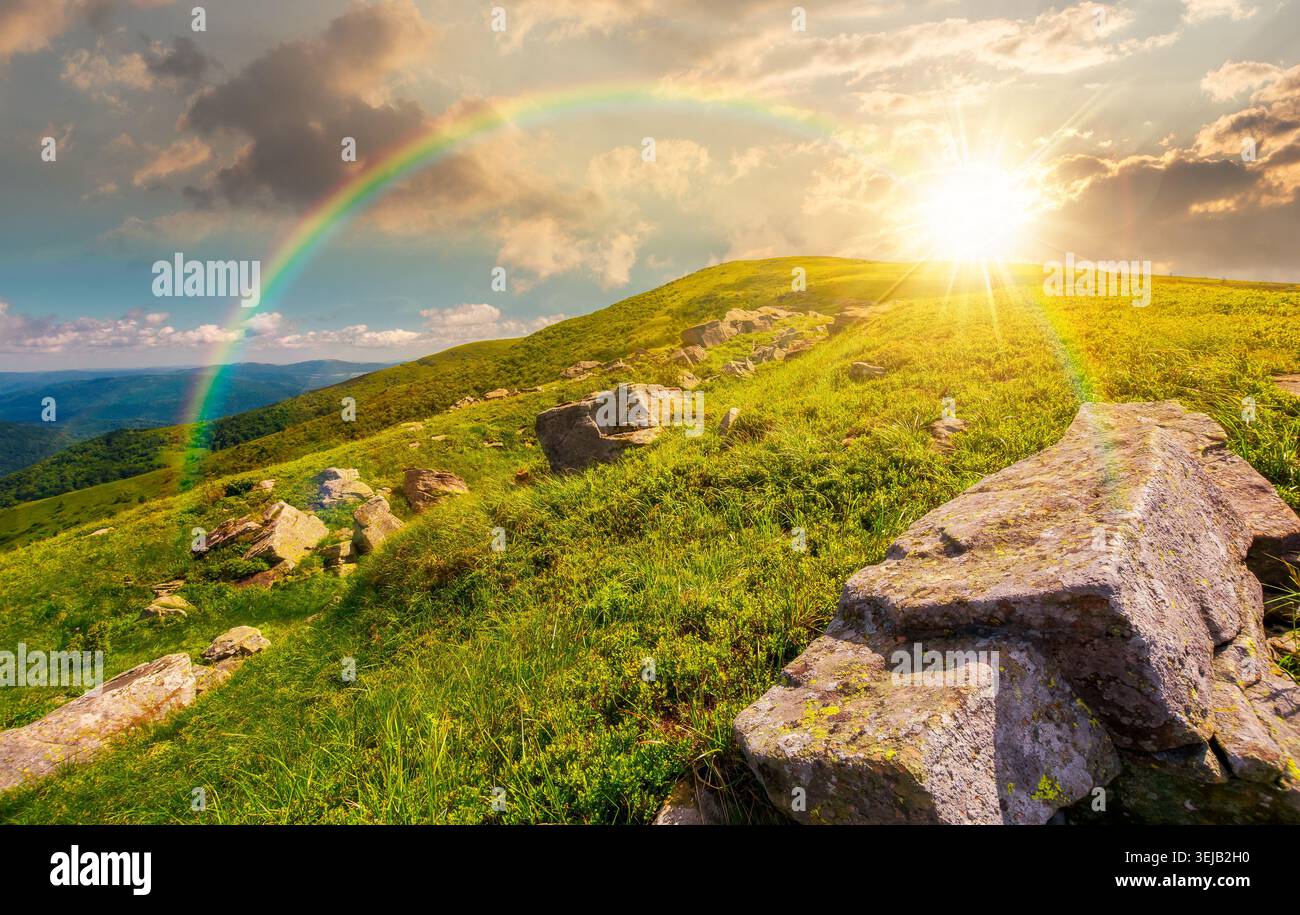 sunset over Carpathian mountain summer landscape. meadow with huge stones among the grass on top of the hillside near the peak of mountain range. alpi Stock Photo