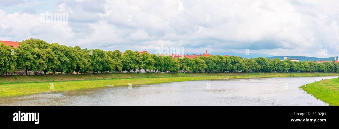 longest linden alley in europe on the Uzh river embankment. lime trees on a sunny summer afternoon. travel destination of transcarpathia. uzhhorod str Stock Photo