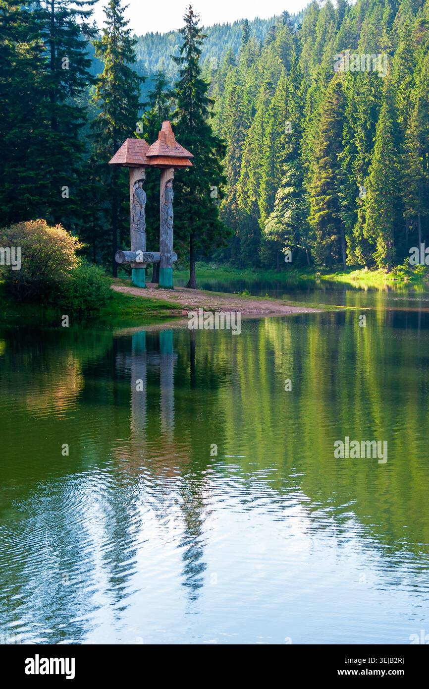 landscape with mountain lake of synevyr national park. green carpathian nature scenery in summer. coniferous forest reflection on the water. popular t Stock Photo