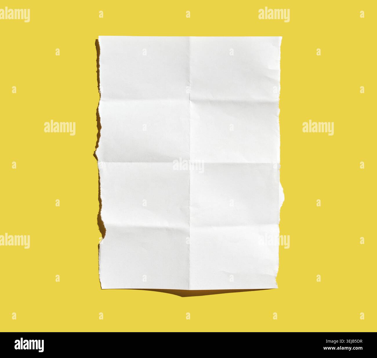 Crumpled white paper sheet on vibrant yellow background highlighting texture and contrast Stock Photo