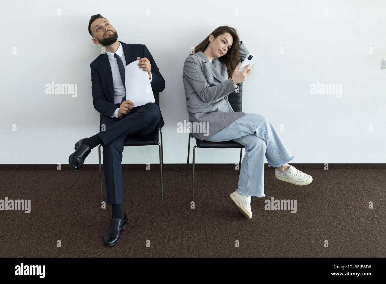 Office employees sit on chairs man and woman waiting for an interview Stock Photo