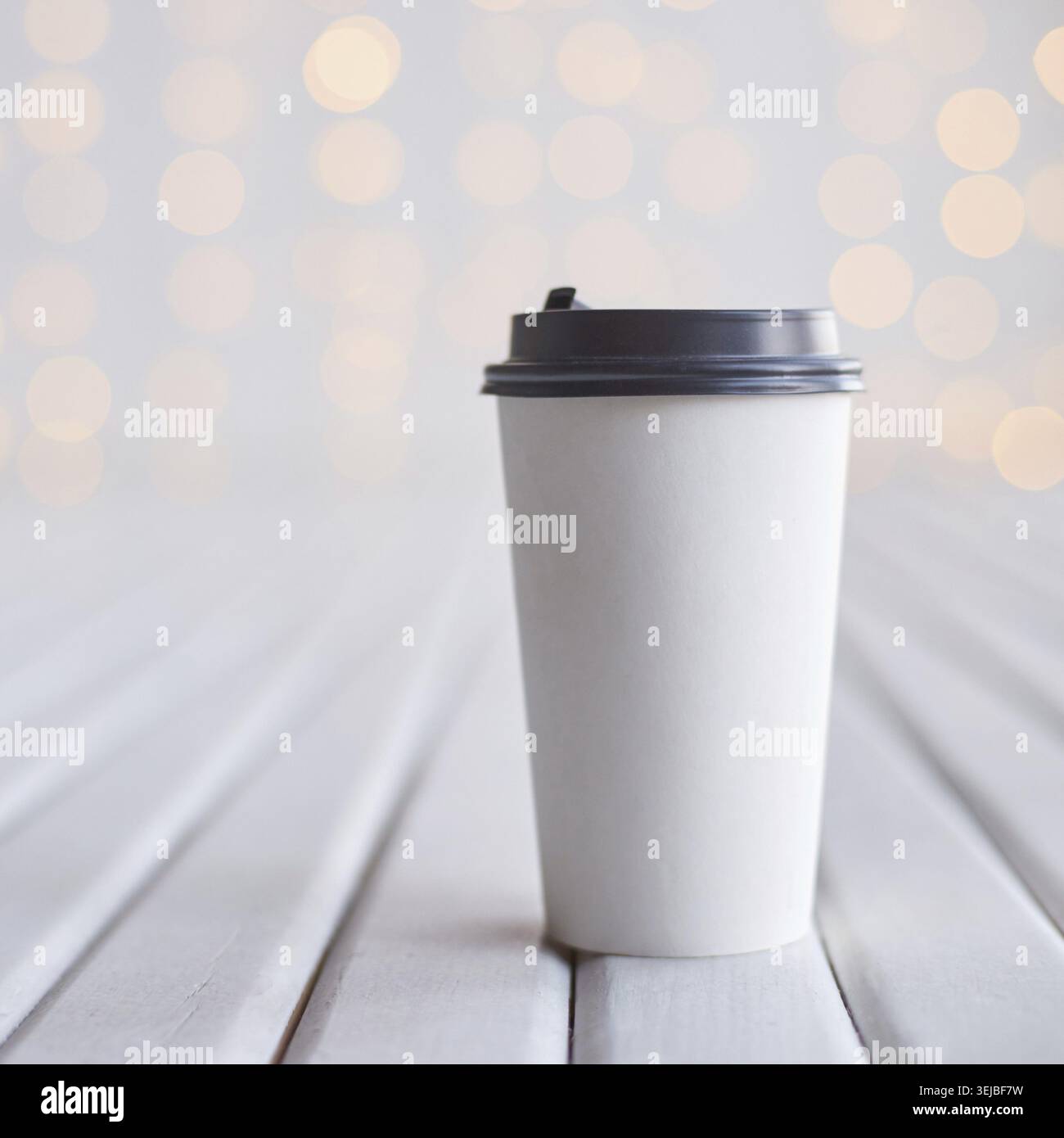 Minimalist white coffee cup on wooden surface with soft bokeh light background for simple and elegant design Stock Photo