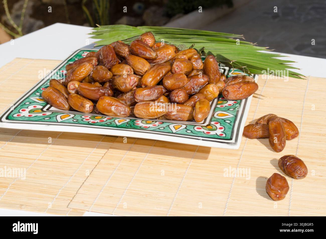 Ripe organic dates served on decorative ceramic plate. Stock Photo