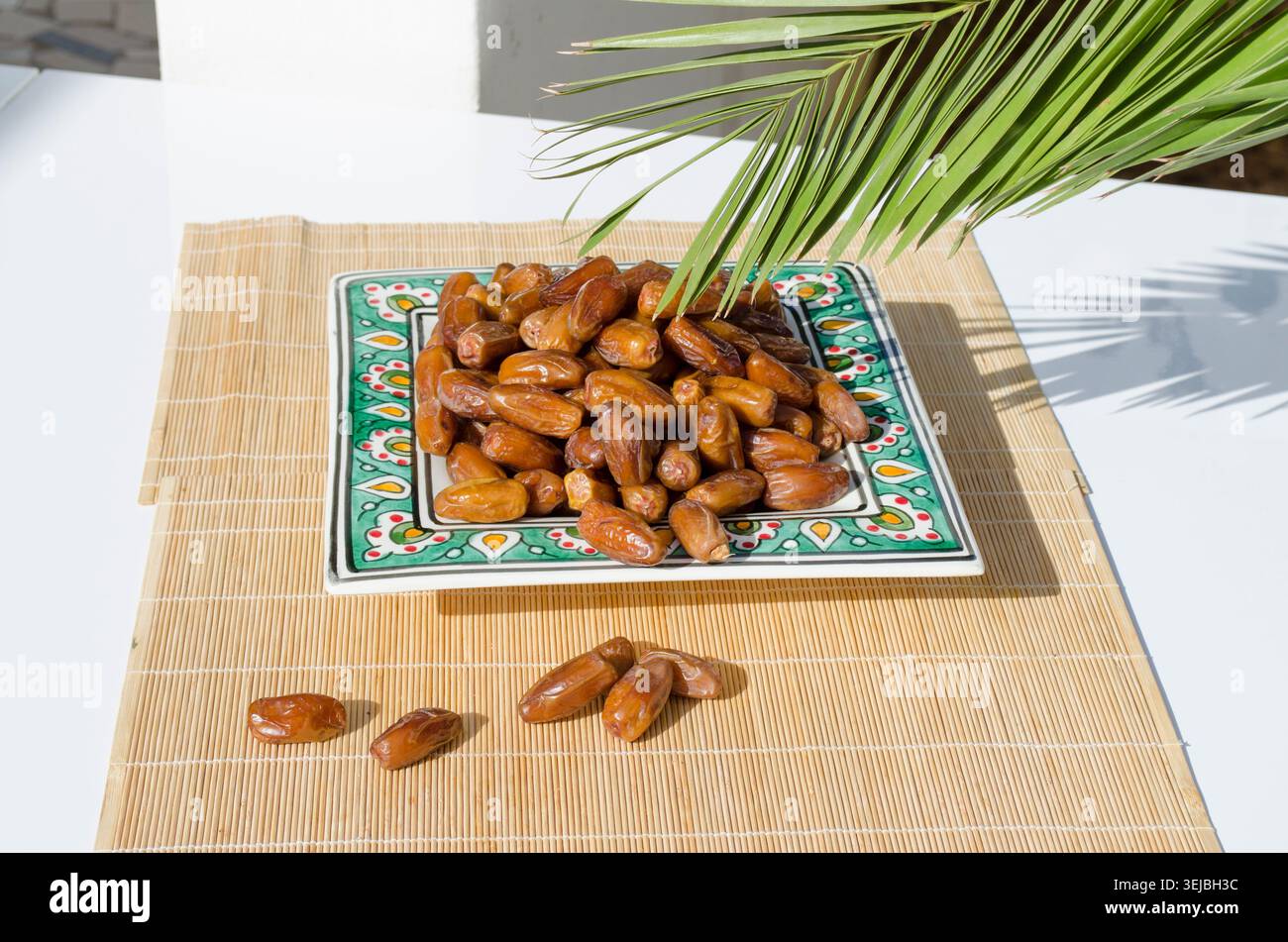 Ripe organic dates served on decorative ceramic plate. Stock Photo